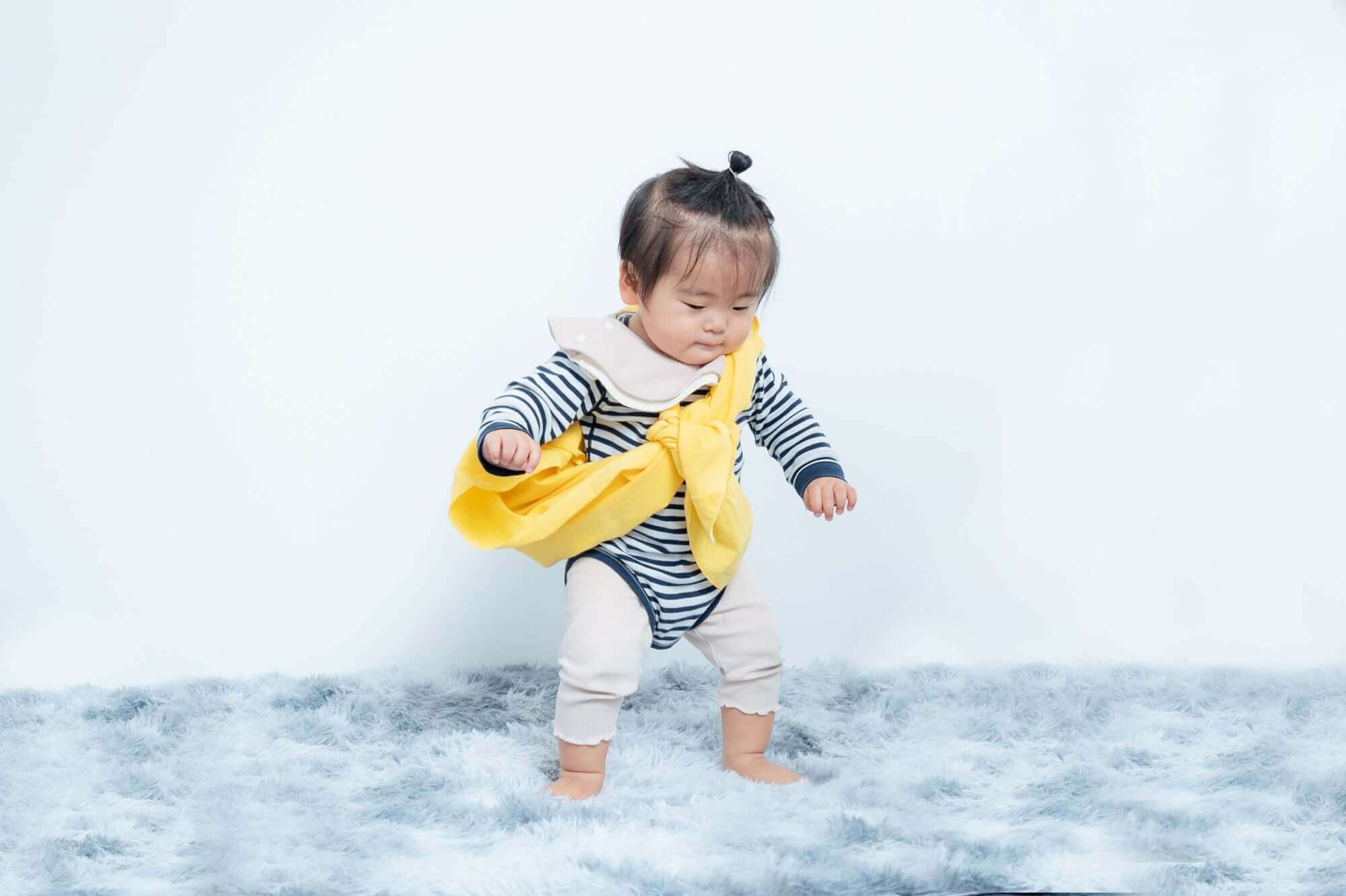 1歳の子供がお祝いのために衣装を着ている姿。フォトスタジオでの誕生日撮影。