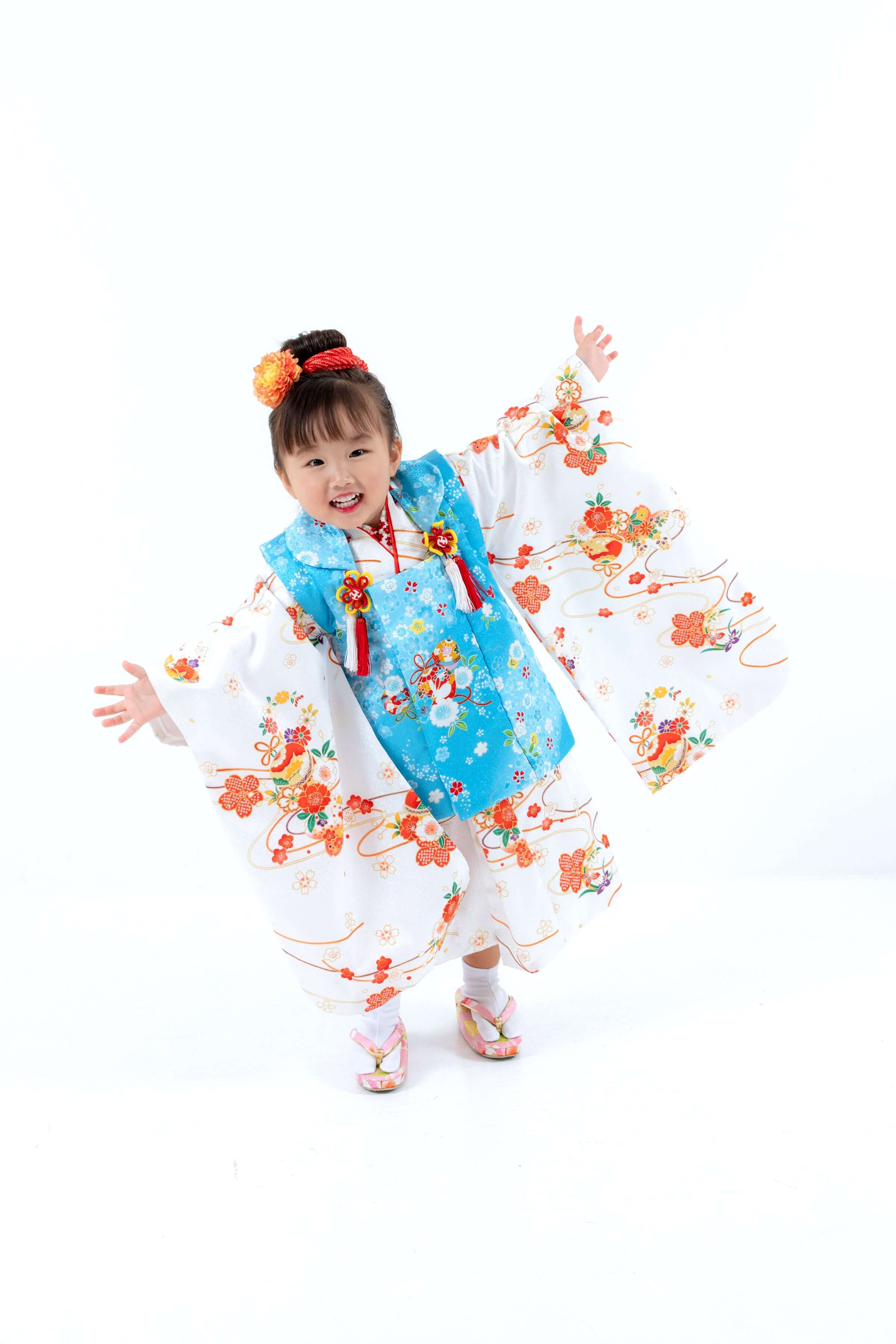 子どもが華やかな七五三の着物を着て楽しそうにポーズをとる様子。フォトウエディング北九州