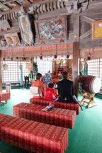 七五三の祝いを受ける子どもたちが神社内で座っている様子。フォトウエディング北九州。