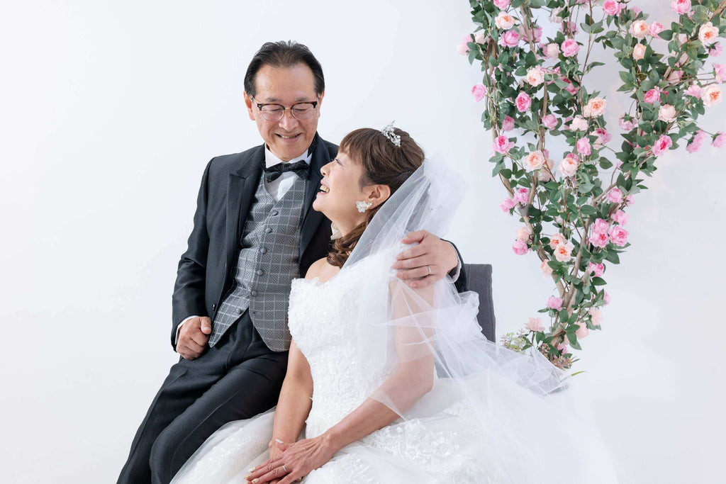 会場でフォトウエディングを楽しむカップル、白いウェディングドレスとタキシード、北九州のスタジオ。
