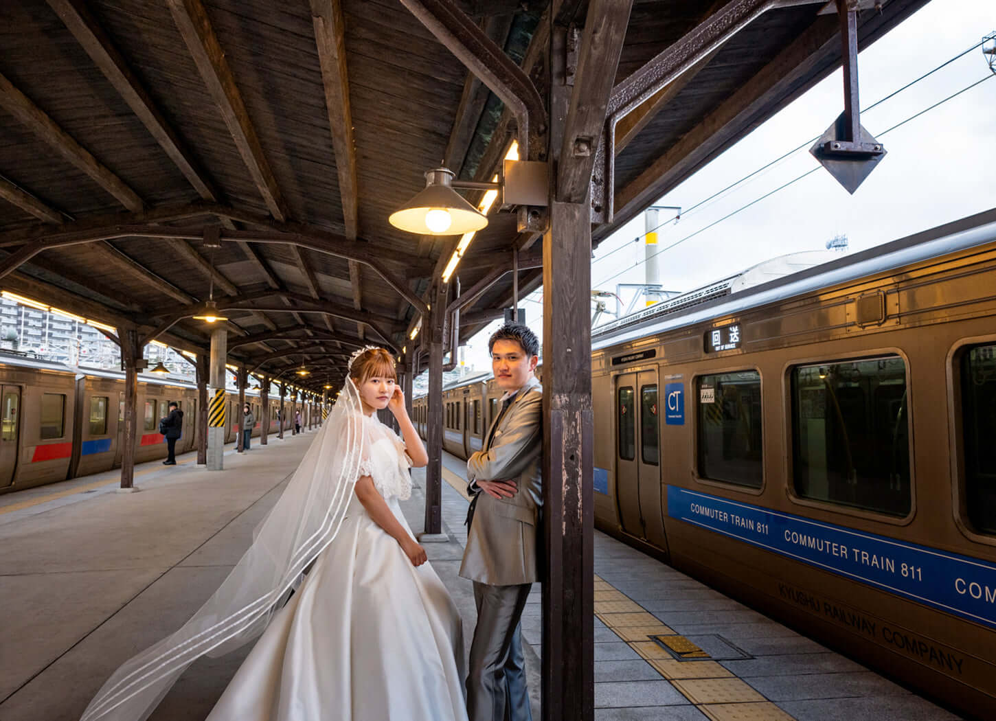フォトウエディング北九州での新郎新婦、鉄道駅での撮影シーン、ブライダルフォト
