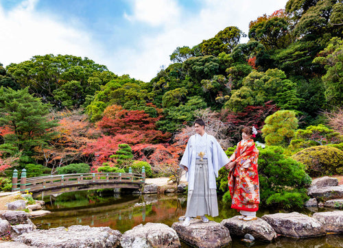 新郎新婦が北九州の庭園で和装のフォトウエディングを楽しむシーン、紅葉が美しい背景