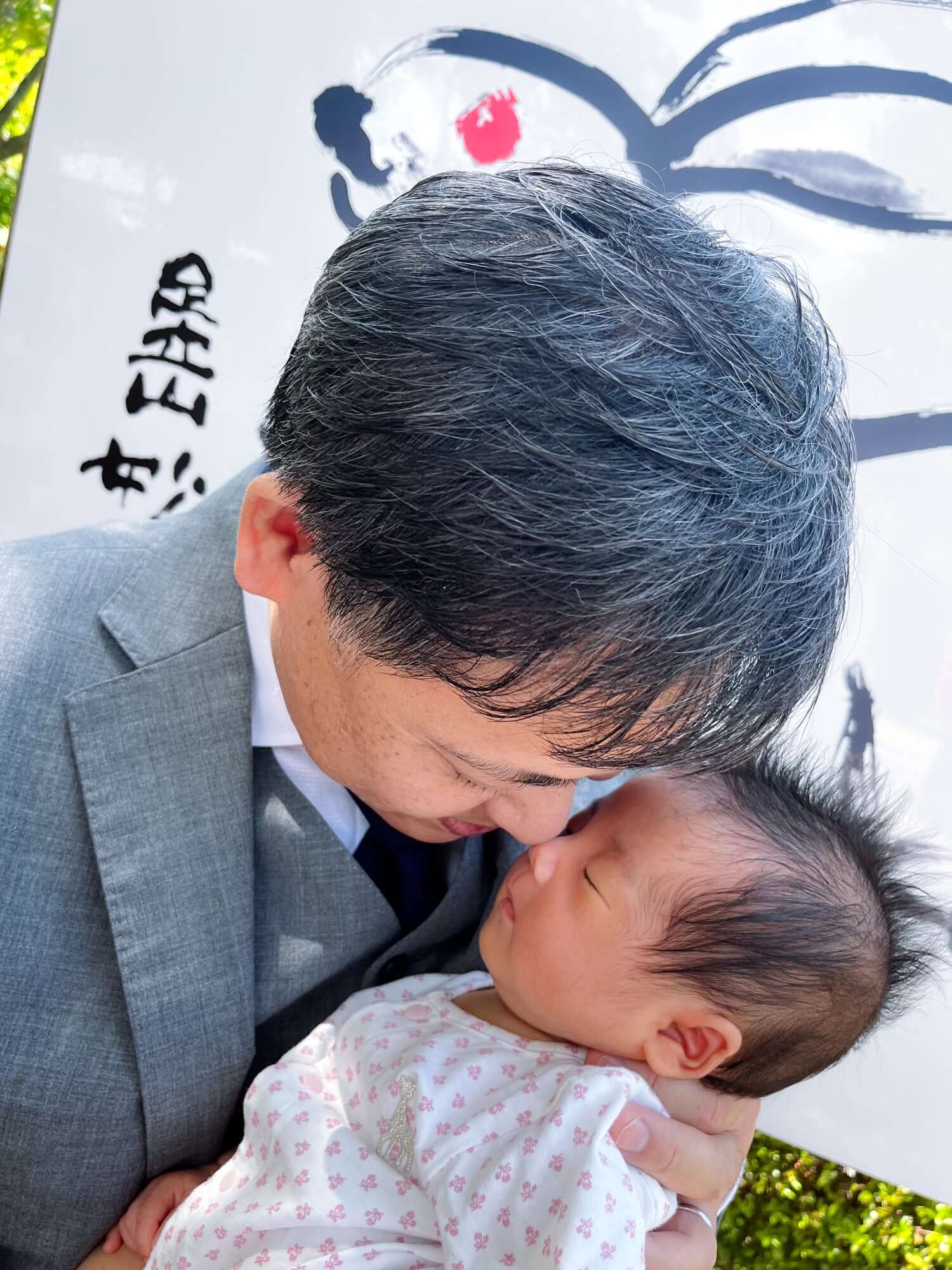 お宮参りの赤ちゃんと父親の愛らしいショット、幸せな瞬間を捉えたフォトウエディング北九州の提案