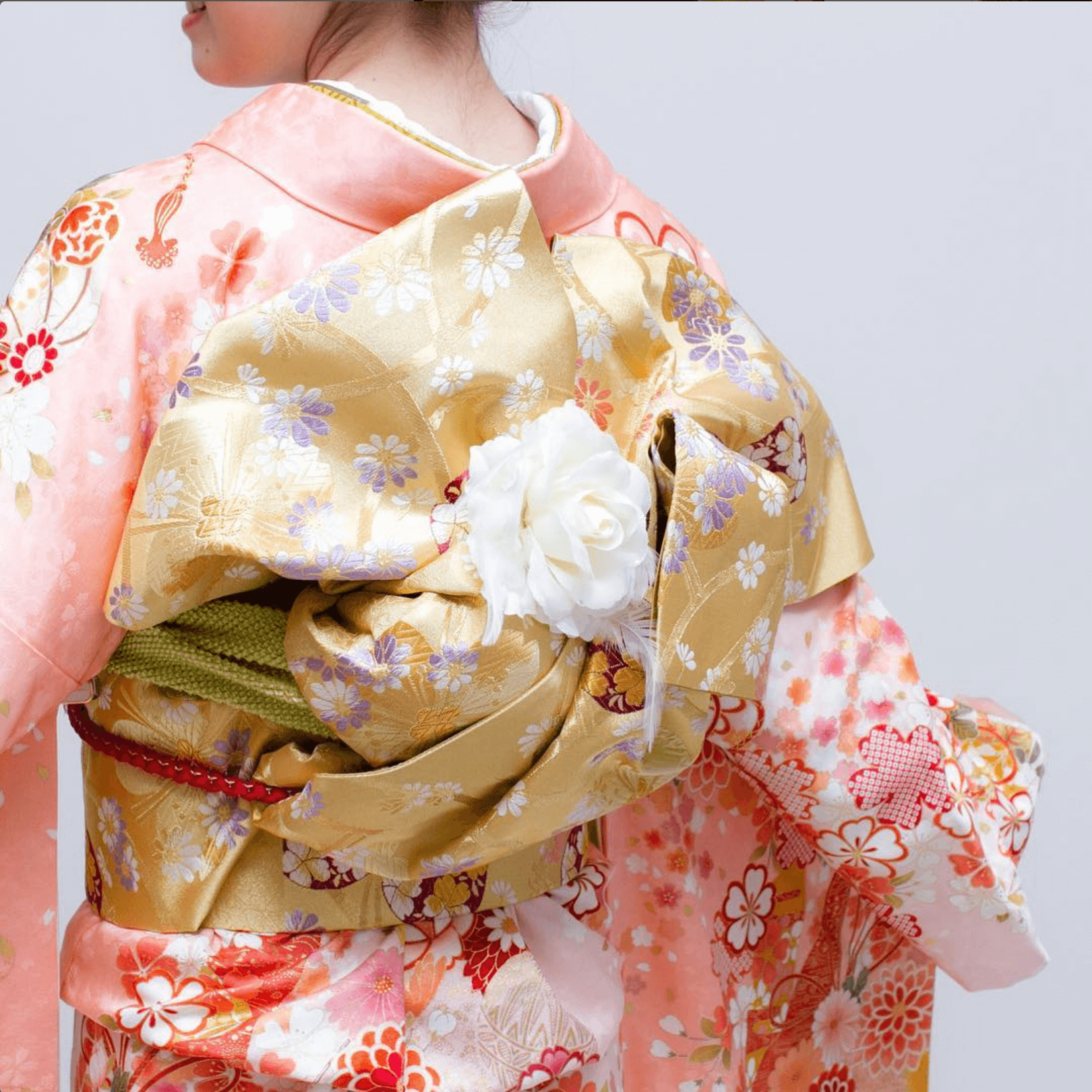 成人式の振袖と金色の帯、白い花で装飾された背中のアップ、フォトウエディング北九州あり
