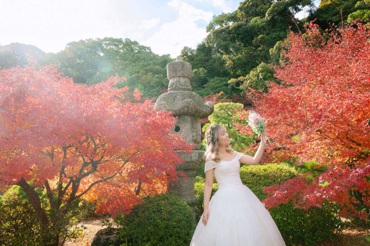 ウエディングドレスを着た新婦が紅葉の中でブーケを持って立つ、フォトウエディング北九州での撮影